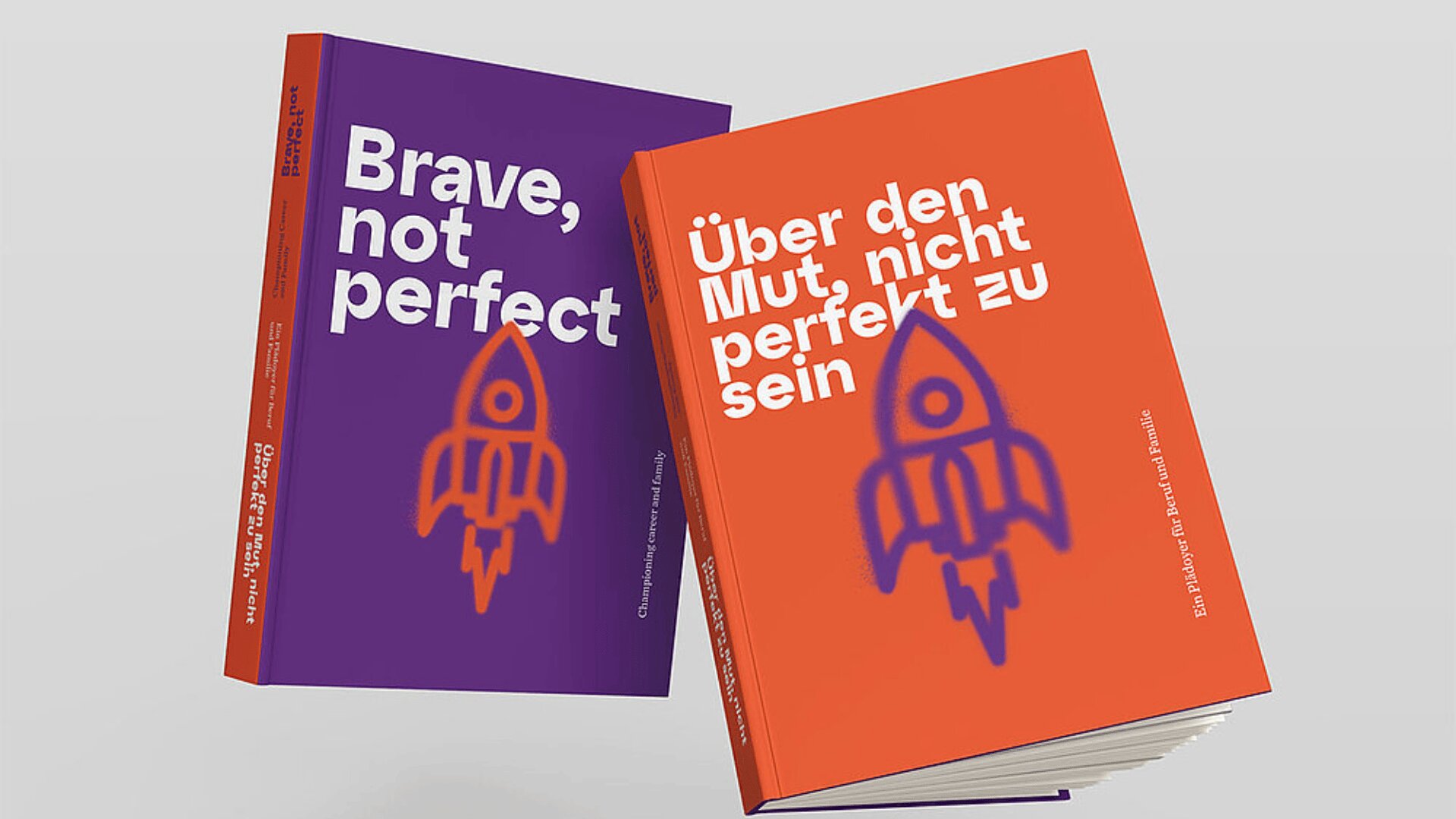 Zwei Bücher stehen aufrecht. Das linke Buch hat einen violetten Einband mit weißem Text, auf dem "Brave, not perfect" steht, und eine einfache Raketenillustration. Das rechte Buch hat einen orangefarbenen Einband mit deutschem Text und der gleichen Raketenillustration.