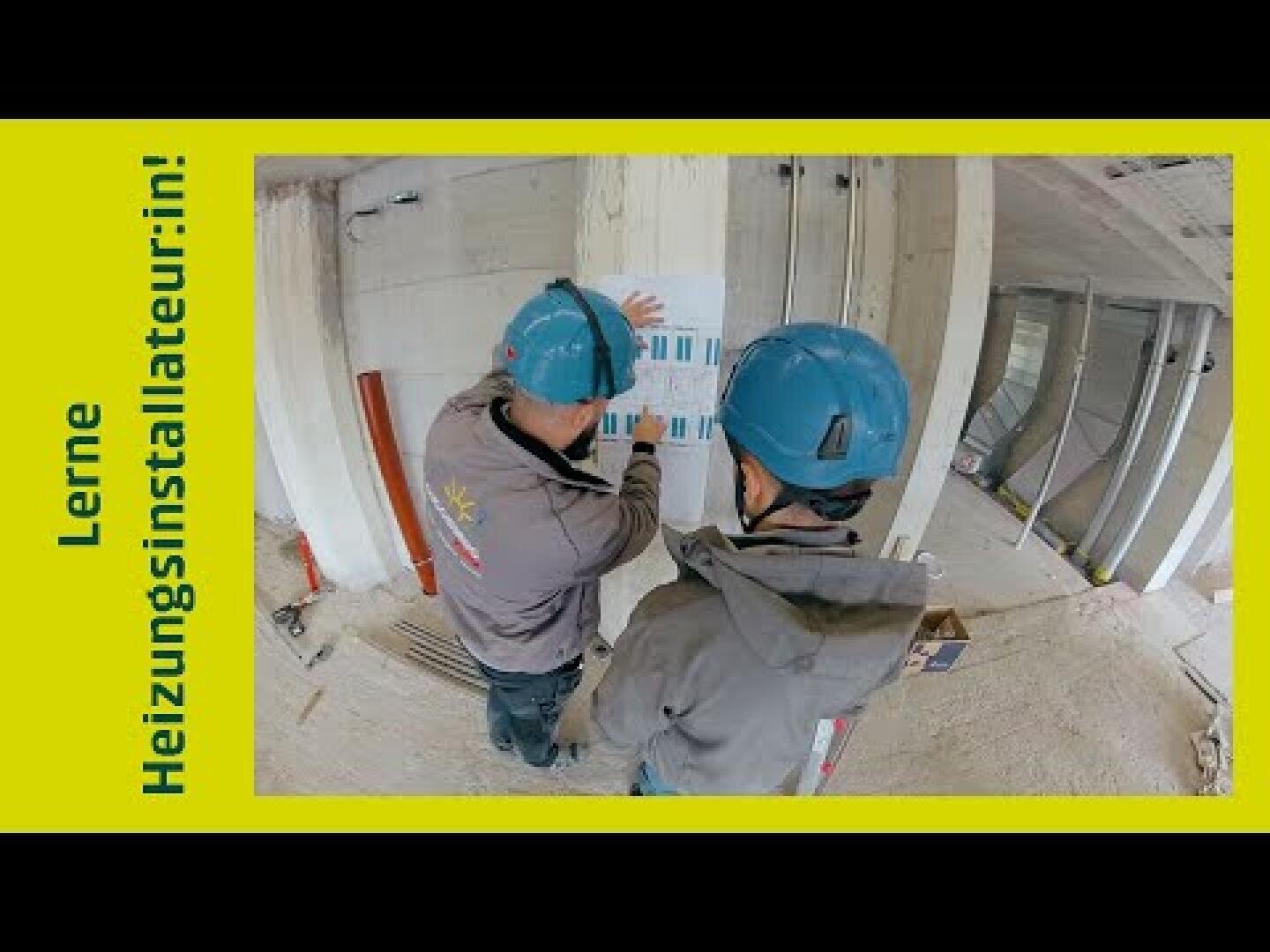 Zwei Bauarbeiter mit blauen Helmen betrachten in einem noch nicht fertiggestellten Raum einen Bauplan. Links ist auf gelbem Hintergrund der deutsche Text „Lerne Heizungsinstallateur:in!“ zu lesen.