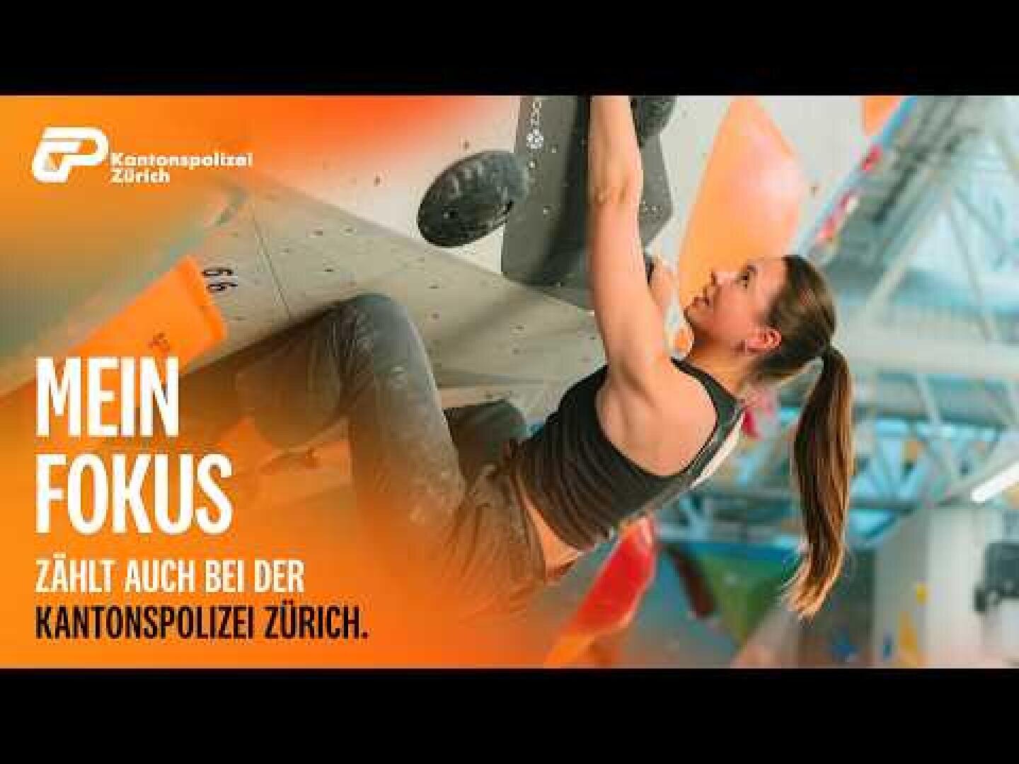 Eine Frau klettert an einer Indoor-Kletterwand. Der Text auf Deutsch lautet: „Mein Fokus zählt auch bei der Kantonspolizei Zürich.“ Das Logo der Kantonspolizei Zürich befindet sich in der oberen linken Ecke.